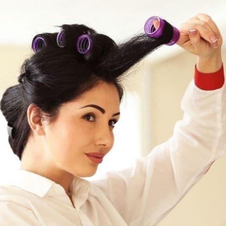 woman removing hair roller for volume
