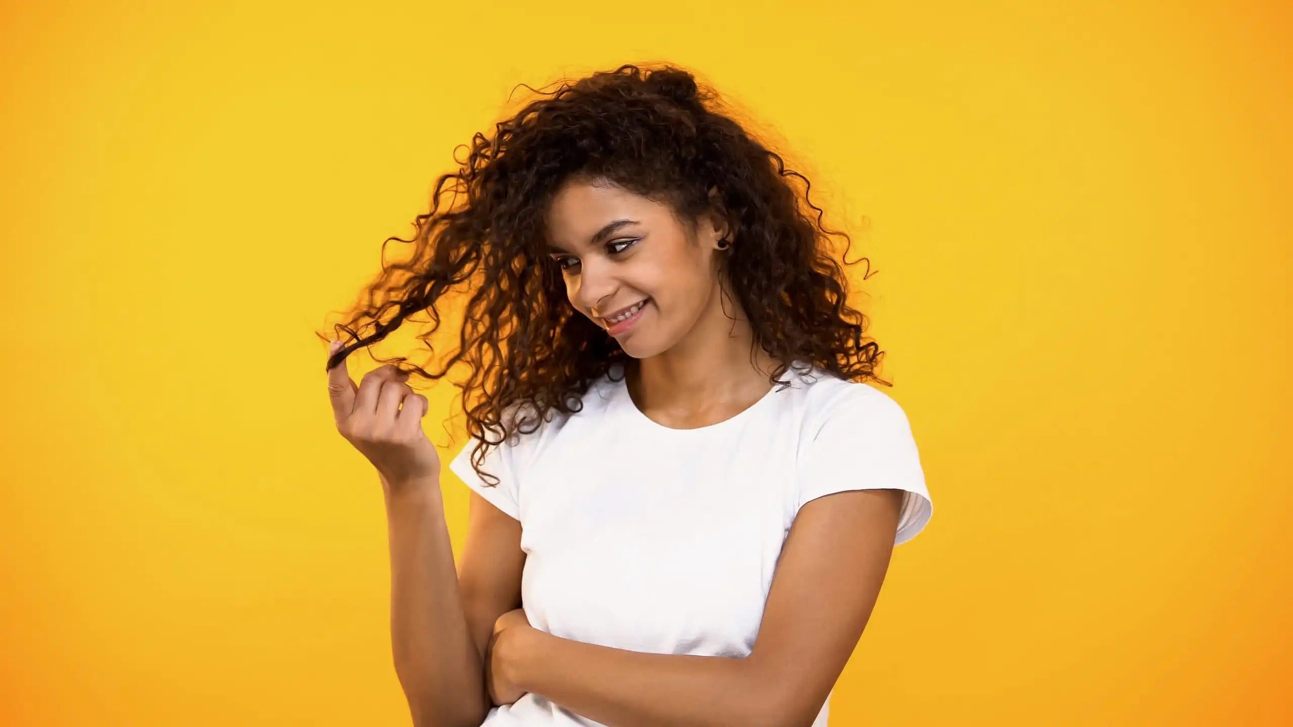 Woman with curly hair on yellow background